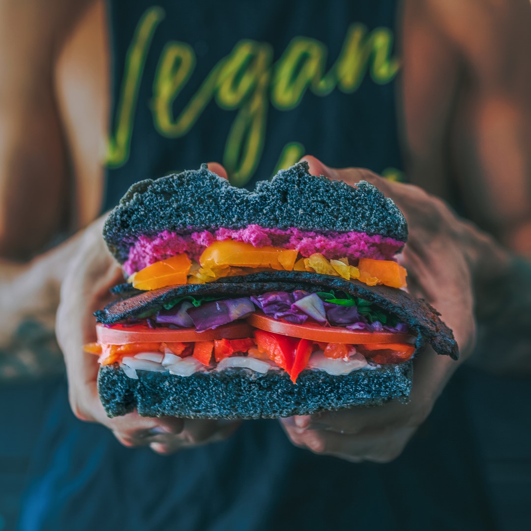 schwarzer Mann hält veganen burger