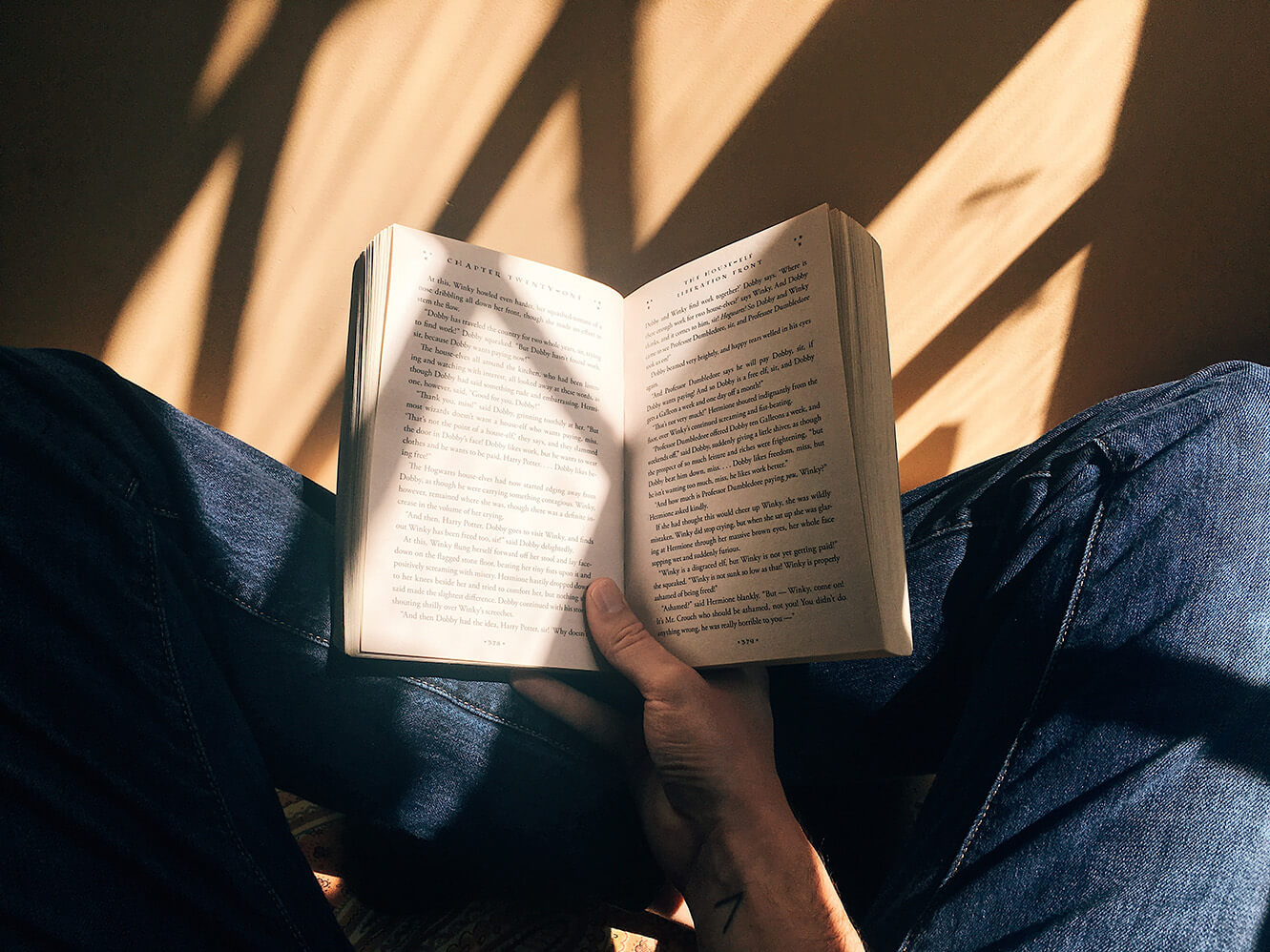 Selbstfürsorge Buchrezension, lesen, Beine auf denen ein aufgeschlagenes Buch liegt