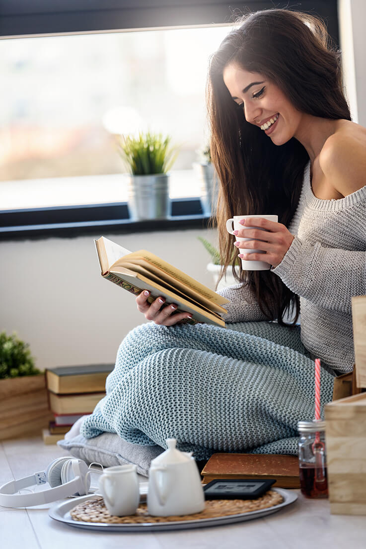 Achtsamkeit Übung lesen, Frau liest ein buch und lächelt